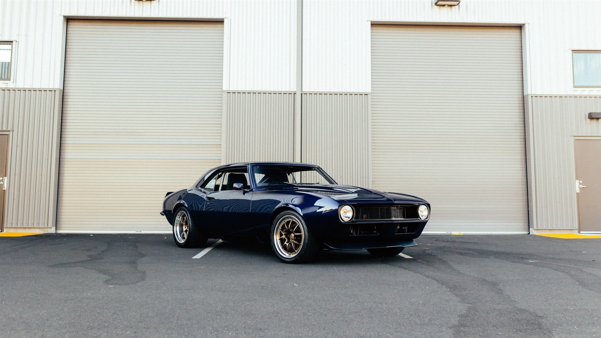 Navy blue restomod 1968 Camaro in front of the Arctic Autowerks shop